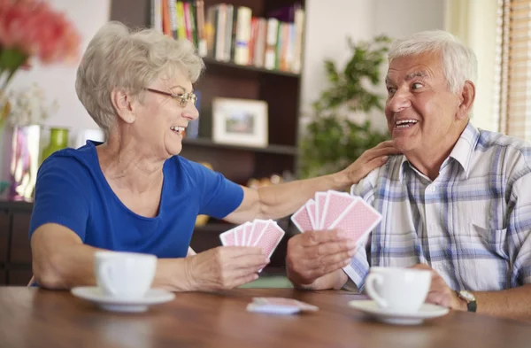 Happy mature couple playing card