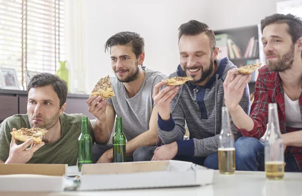 Friends eat pizza with beer.