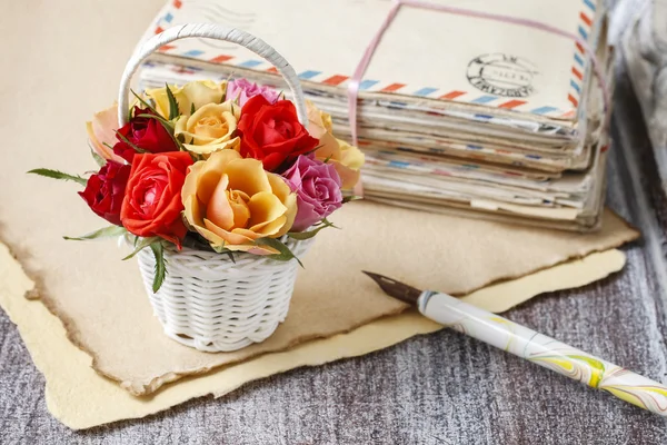Basket of colorful roses and vintage letters