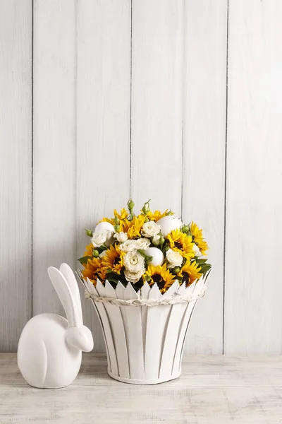 Bouquet of white roses and sunflowers and ceramic rabbit