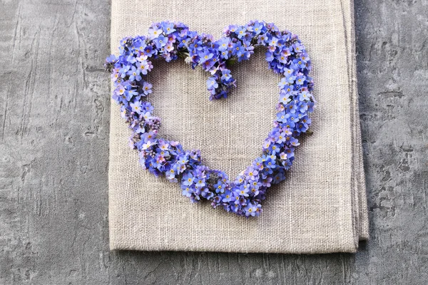 Heart shaped wreath made of forget-me-not flowers.