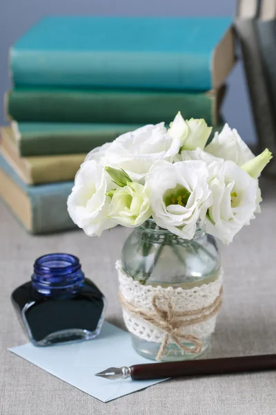 Bouquet of white eustoma flowers, bottle of ink and vintage pen