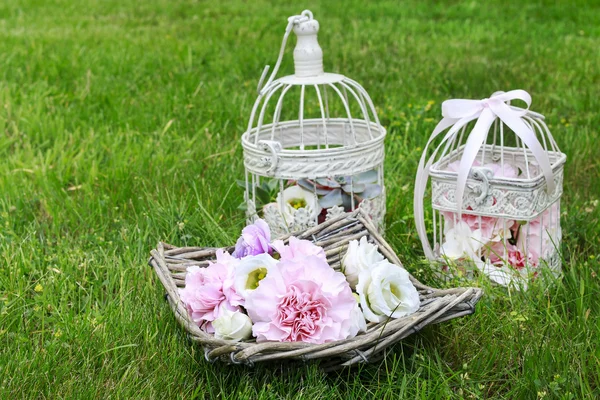 Party decorations: basket of flowers and vintage bird cages with