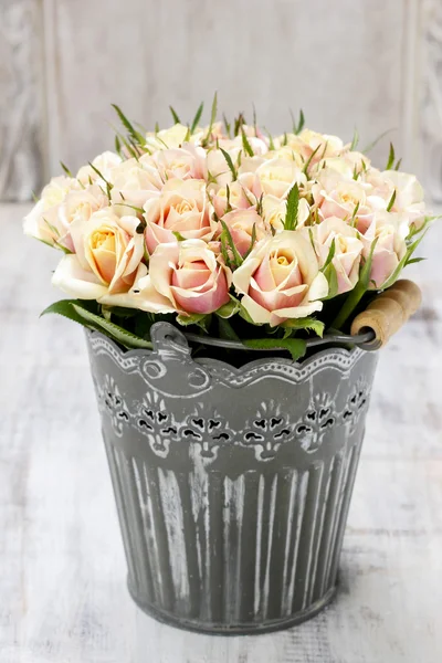 Bouquet of roses in grey decorative bucket