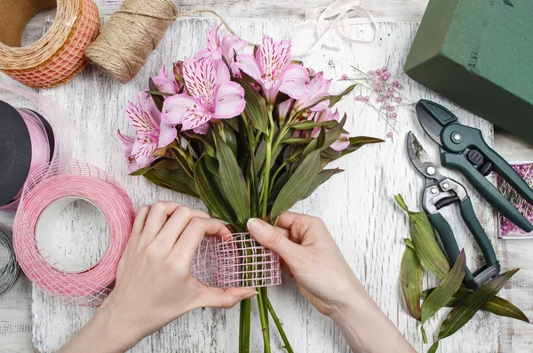 Florist at work: woman arranging bouquet of alstroemeria flowers