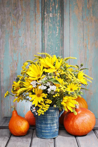 Bouquet of sunflowers and wild flowers on wooden table