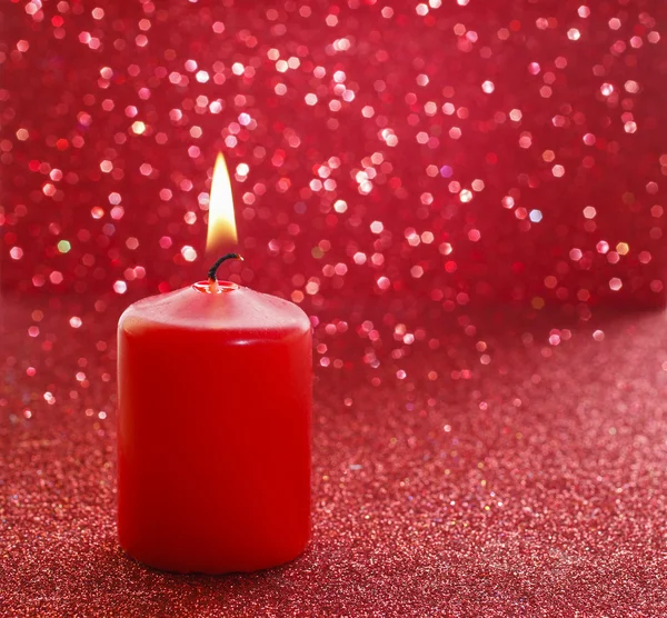 Red candle. Red glittering christmas lights.