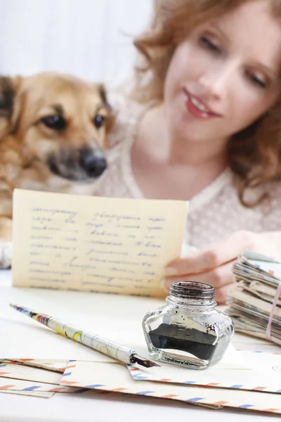 Woman reading letter to a lovely puppy.