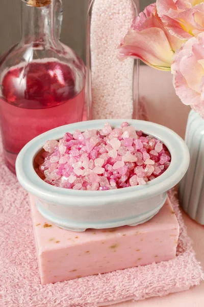 Bowl of pink sea salt, bar of handmade soap and bottle of liquid