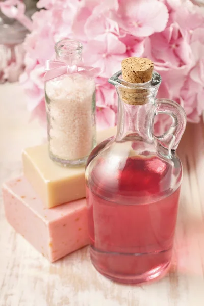 Bottle of pink liquid soap and bottle of sea salt