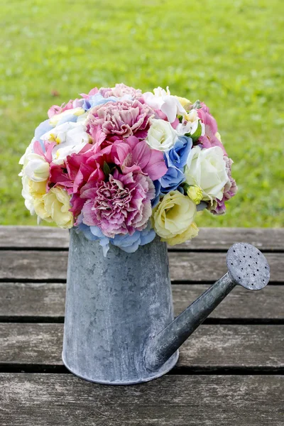 Bouquet of flowers in silver watering can
