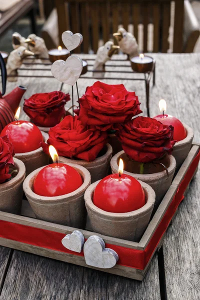 Romantic decoration with roses and scented candles in wooden box