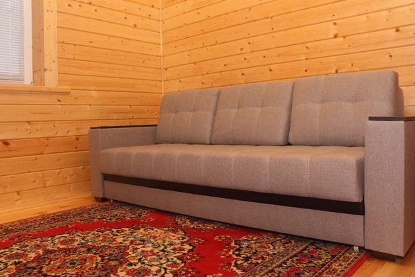 Wooden house interior - sofa and carpet