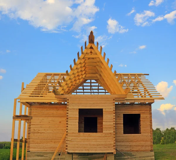 Timber house under constructoin with roof frame front view