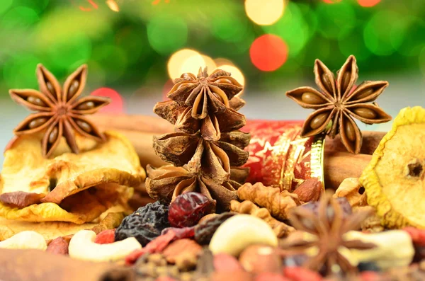 Christmas spices, nuts, cookies and dried fruits on bokeh background