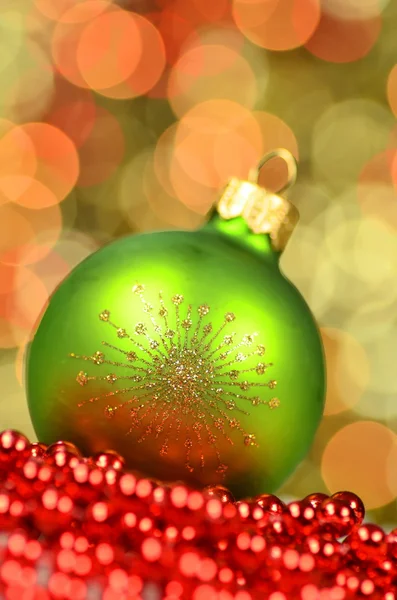 Christmas decoration, green Christmas ball in bokeh background