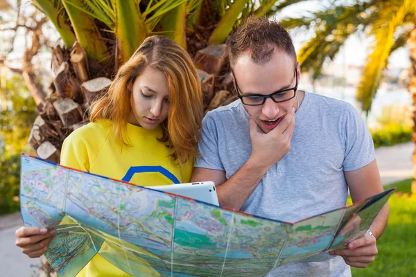 Couple with map pointing at destination.