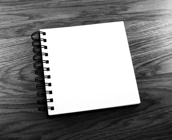 Notepad with a spiral binding on a wooden background.