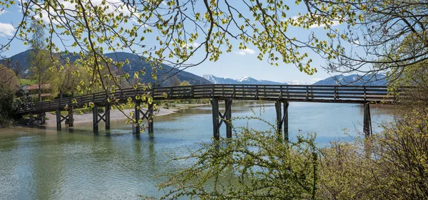 Wooden bridge over mangfall river, view to lake tegernsee