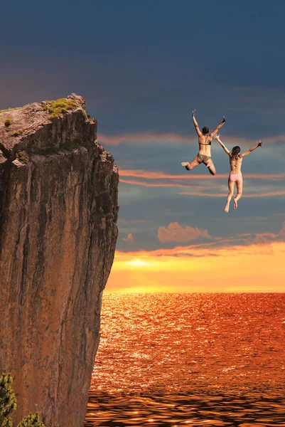 Two cliff jumping girls, sunset scenery