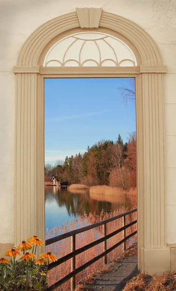 View through arched door, autumnal lake shore