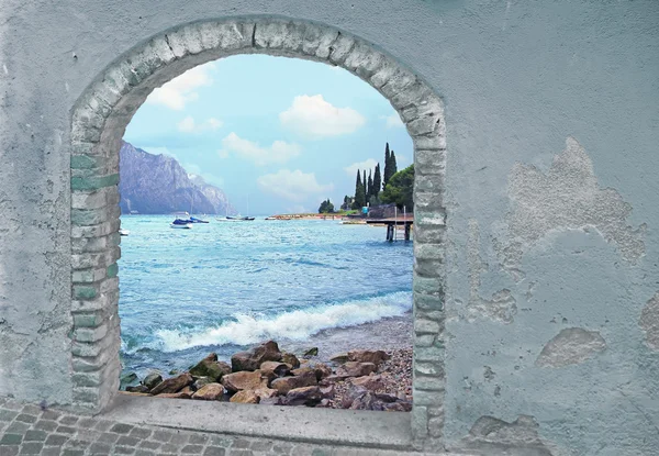 View through rustic vintage door, mountain lake and mediterranea
