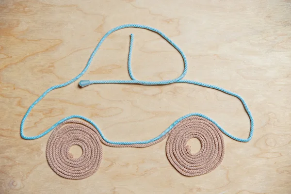Automobile, made of a cord string on wooden background