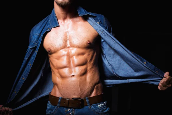 Muscular and sexy young man in jeans shirt with perfect fitness body