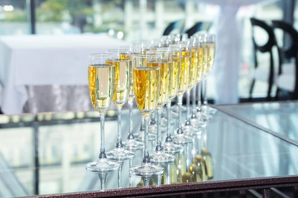 Elegant glasses with champagne standing in a row