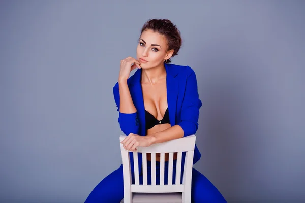 Portrait of gorgeous young caucasian attractive sexy woman with wearing blue jacket, pants and black bra .