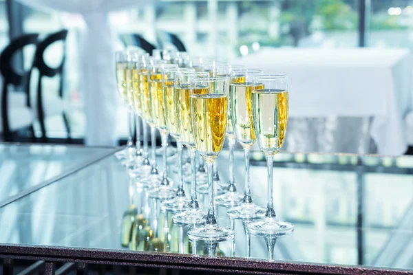 Elegant glasses with champagne standing in a row on table