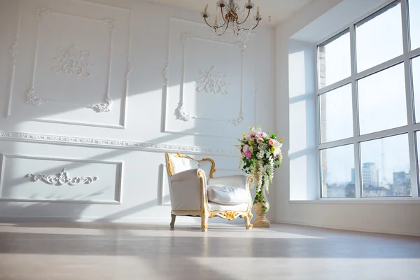 White leather vintage style chair in classical interior room with big window and spring flowers