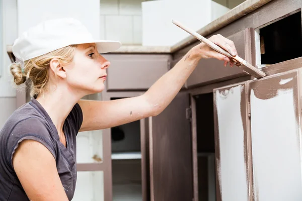Closeup of Woman Painting Kitchen Cabinets