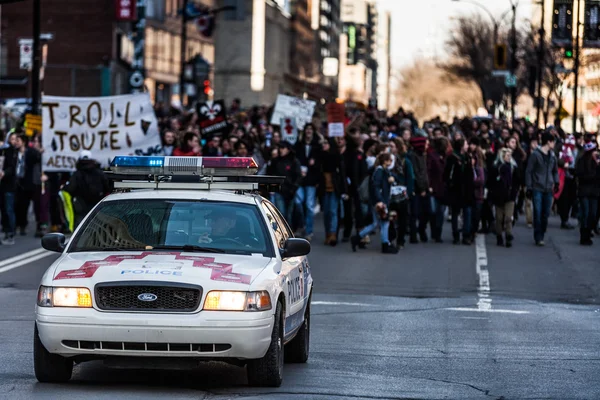 Police Car in front of the Protesters controlling the Traffic