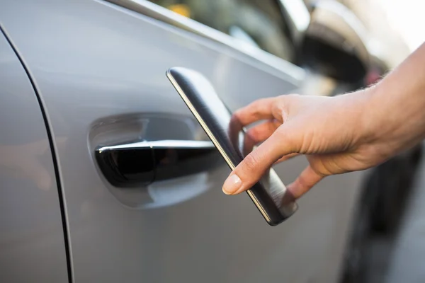 Woman opens her car with her smart phone