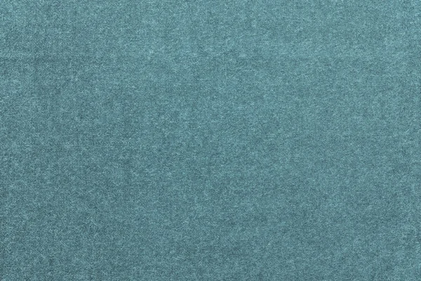 Speckled textured monochrome background from fabric of pale turquoise color