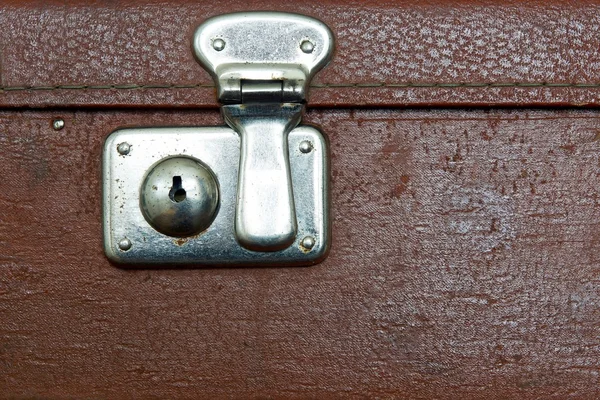 Closed lock of an old suitcase dark brown color