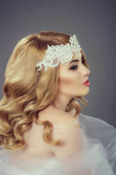 Beautiful young bride with blond hair under a veil
