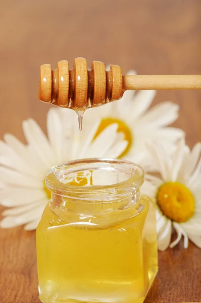 Jar of honey and a spoonful of honey