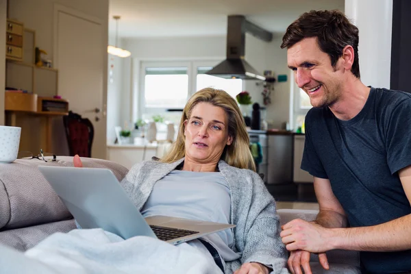 Joyful couple working  on laptop