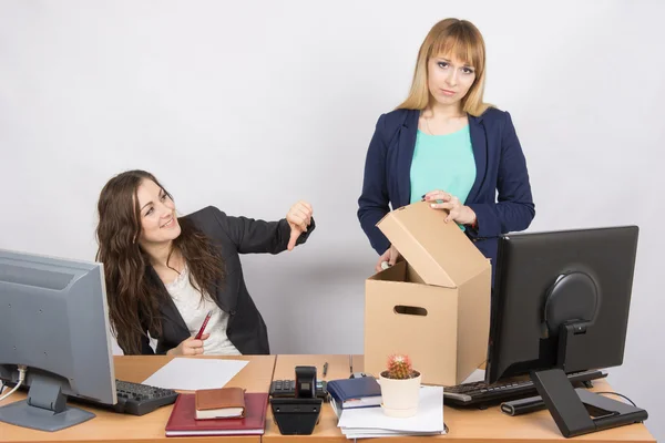 Office woman with a humiliating gesture unsettled the dismissed colleague