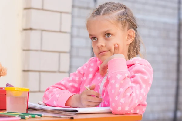 Schoolgirl thought drawing on the album in pencil, in the yard