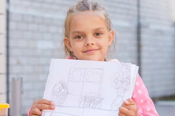 A girl shows a drawing, drawn in pencil