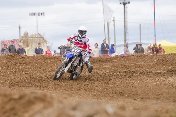 Volgograd, Russia - April 19, 2015: Motorcycle racer insured against falling outstretched leg in the corner, at the stage of the Open Championship Motorcycle Cross Country Cup Volgograd Region Governo