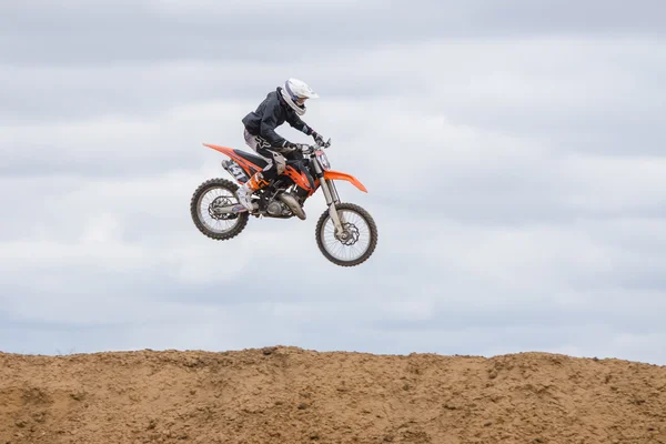 Volgograd, Russia - April 19, 2015: Motorcycle racer jumped above the ground on the springboard, at a stage of the open championship motorcycling Cup cross-country Volgograd Region Governor