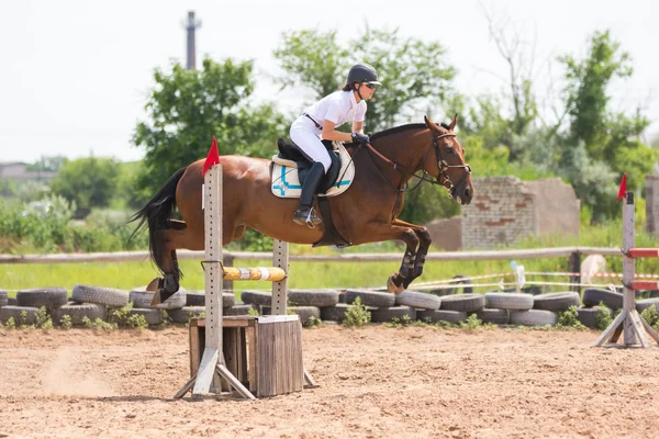 Volgograd, Russia - June 19, 2016: sportsman on horse jumping over a hurdle at the competition in show jumping