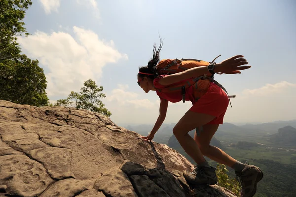 Asian woman climbing on ock