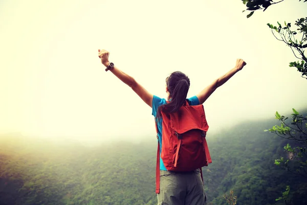 Woman with open arms on mountain