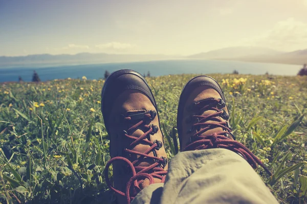 Hiker sitting on grass mountain top