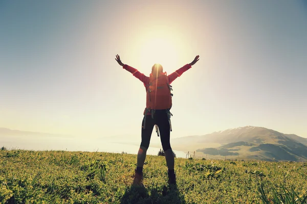 Cheering successful woman backpacker